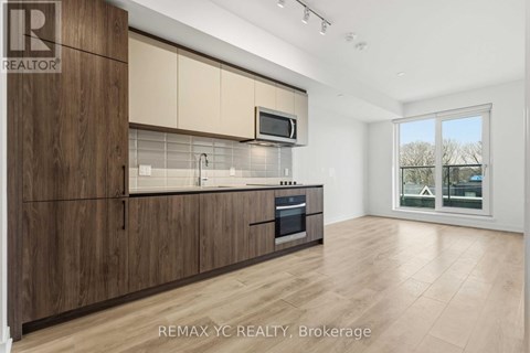 A kitchen with wooden cabinets and a microwave above the oven.