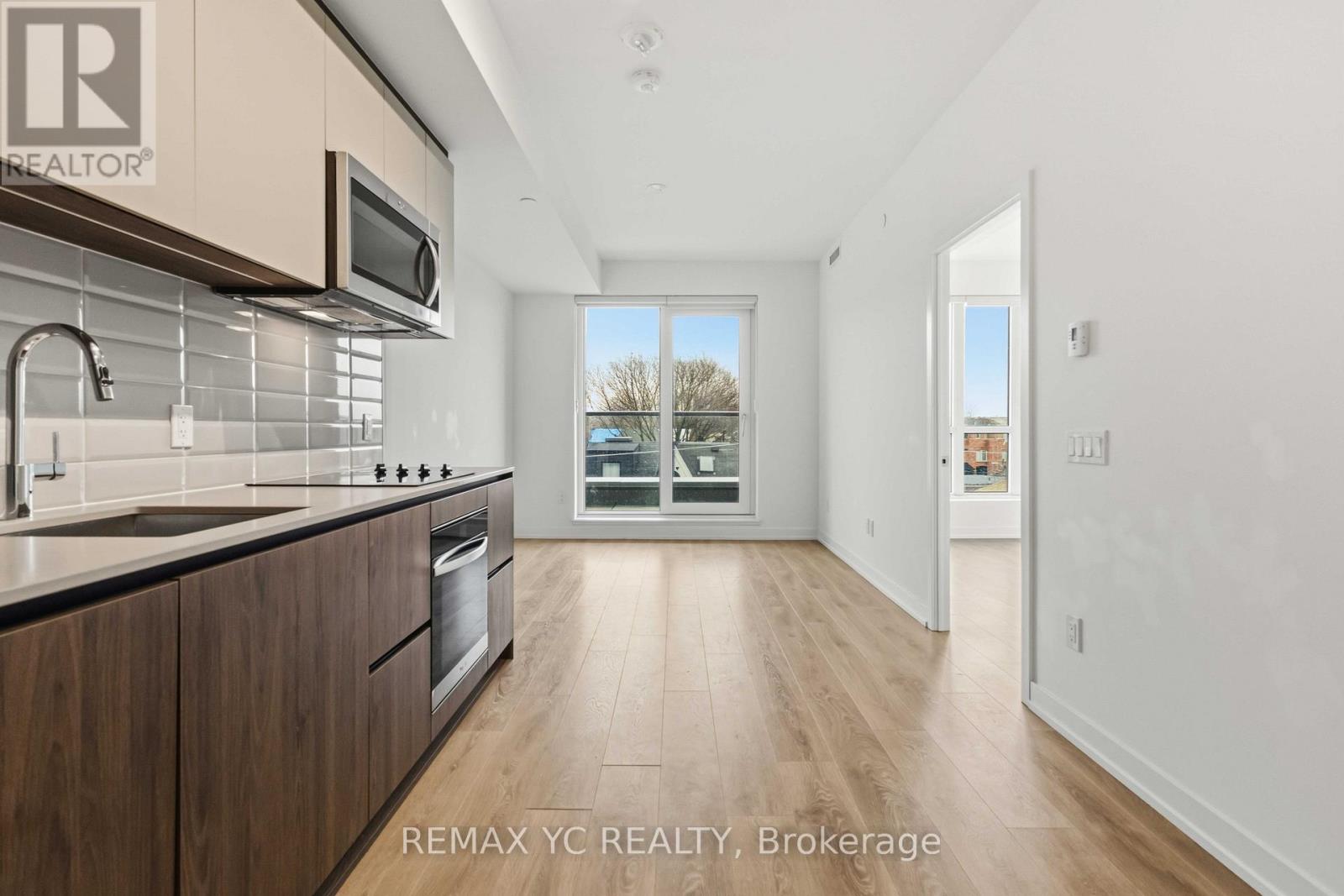 A modern kitchen with wooden cabinets and a stainless steel oven.