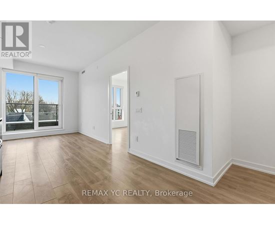 A spacious, empty room with a sliding glass door and a radiator on the wall.