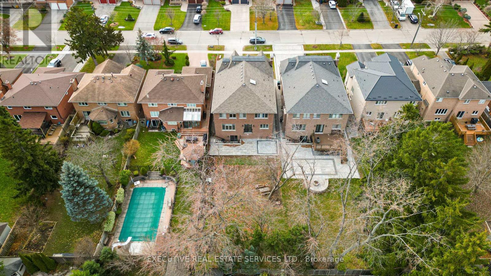 A bird's eye view of a residential area with houses and a pool.