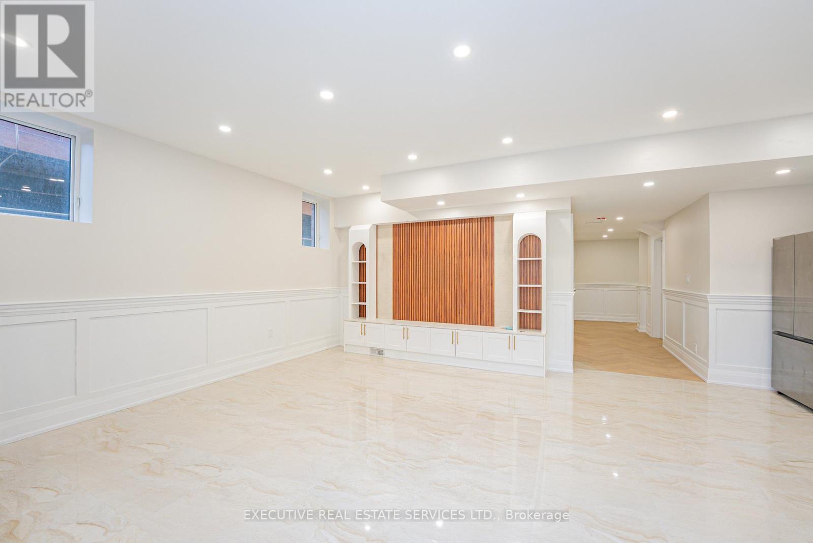 A spacious room with marble flooring and white walls.