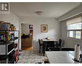 A kitchen with a dining table and chairs.