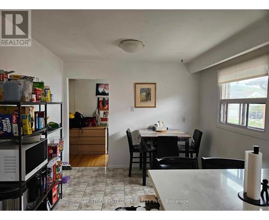 A kitchen with a dining table and chairs.