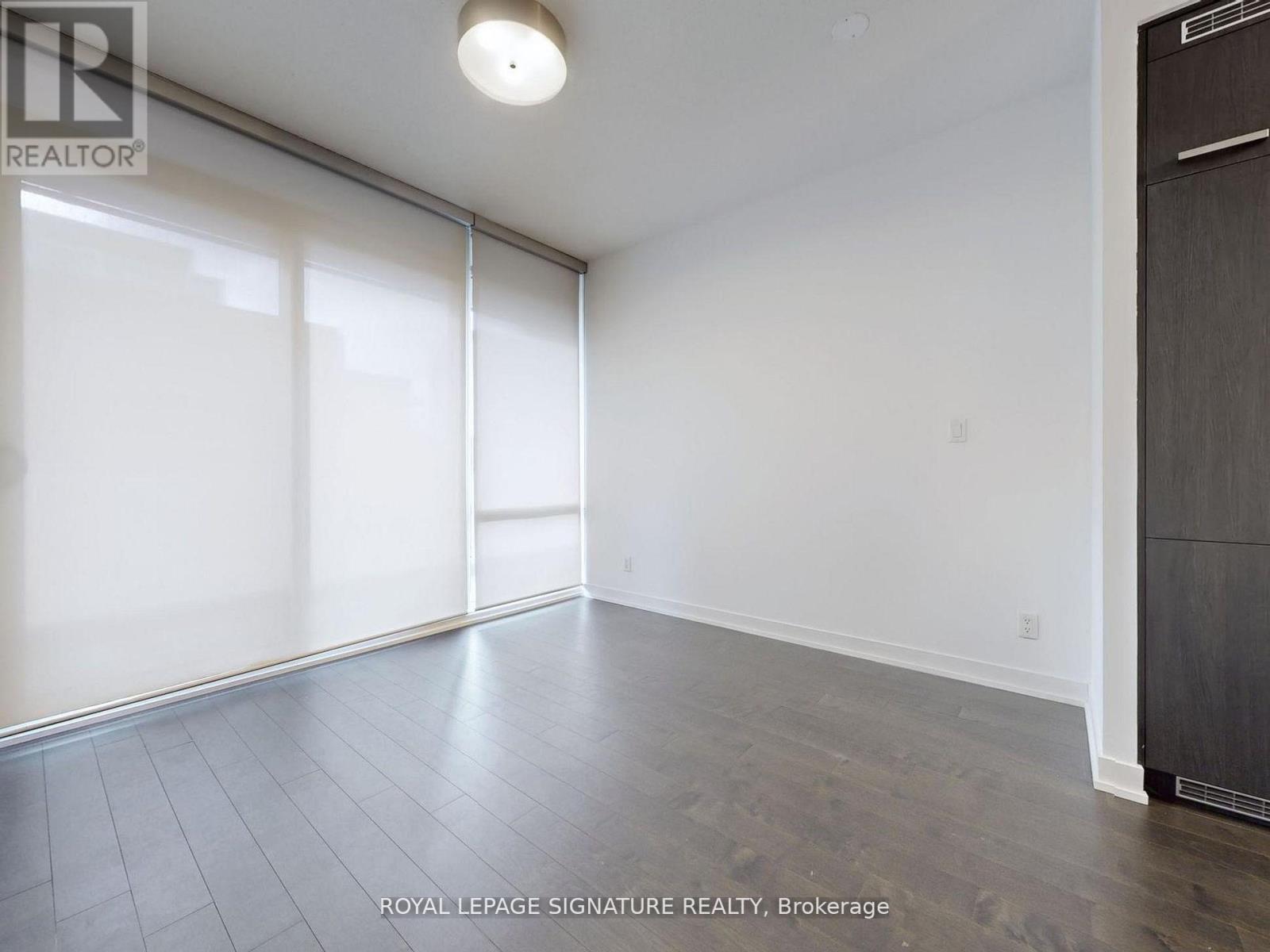 A spacious room with a sliding door and a wooden floor.