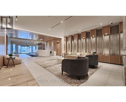 A modern living room with a large grey sofa and a wooden floor.