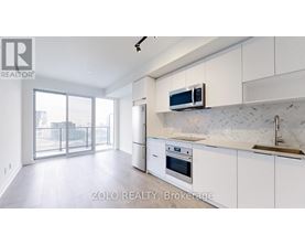 A modern kitchen with white cabinets and a marble backsplash.