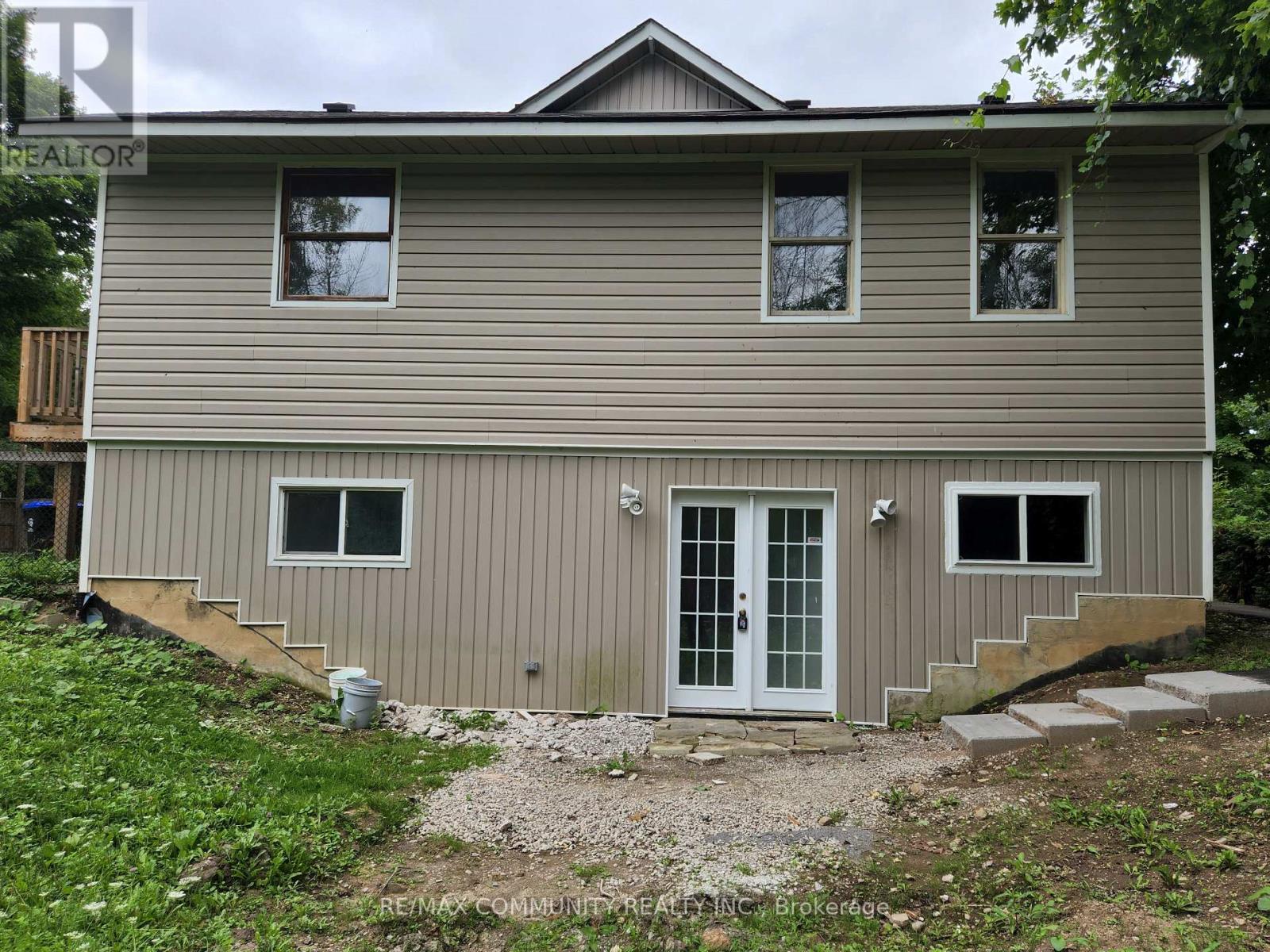 A house with a grey siding and a white door is shown.