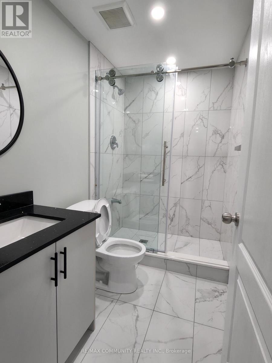 A bathroom with a marble tile shower and toilet.