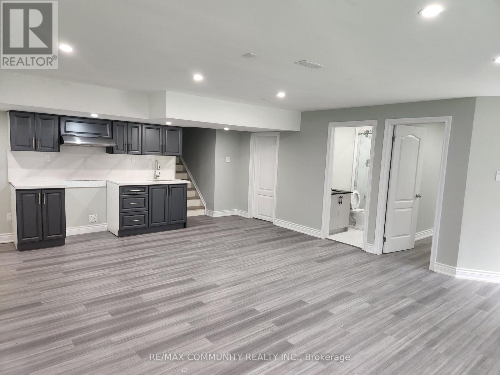 A spacious kitchen with dark wood cabinets and a white island.