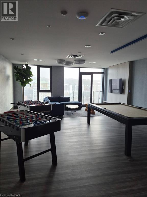 A pool table is in the middle of a room with a couch and a TV.