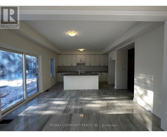 A spacious kitchen and living room with a large island in the middle.