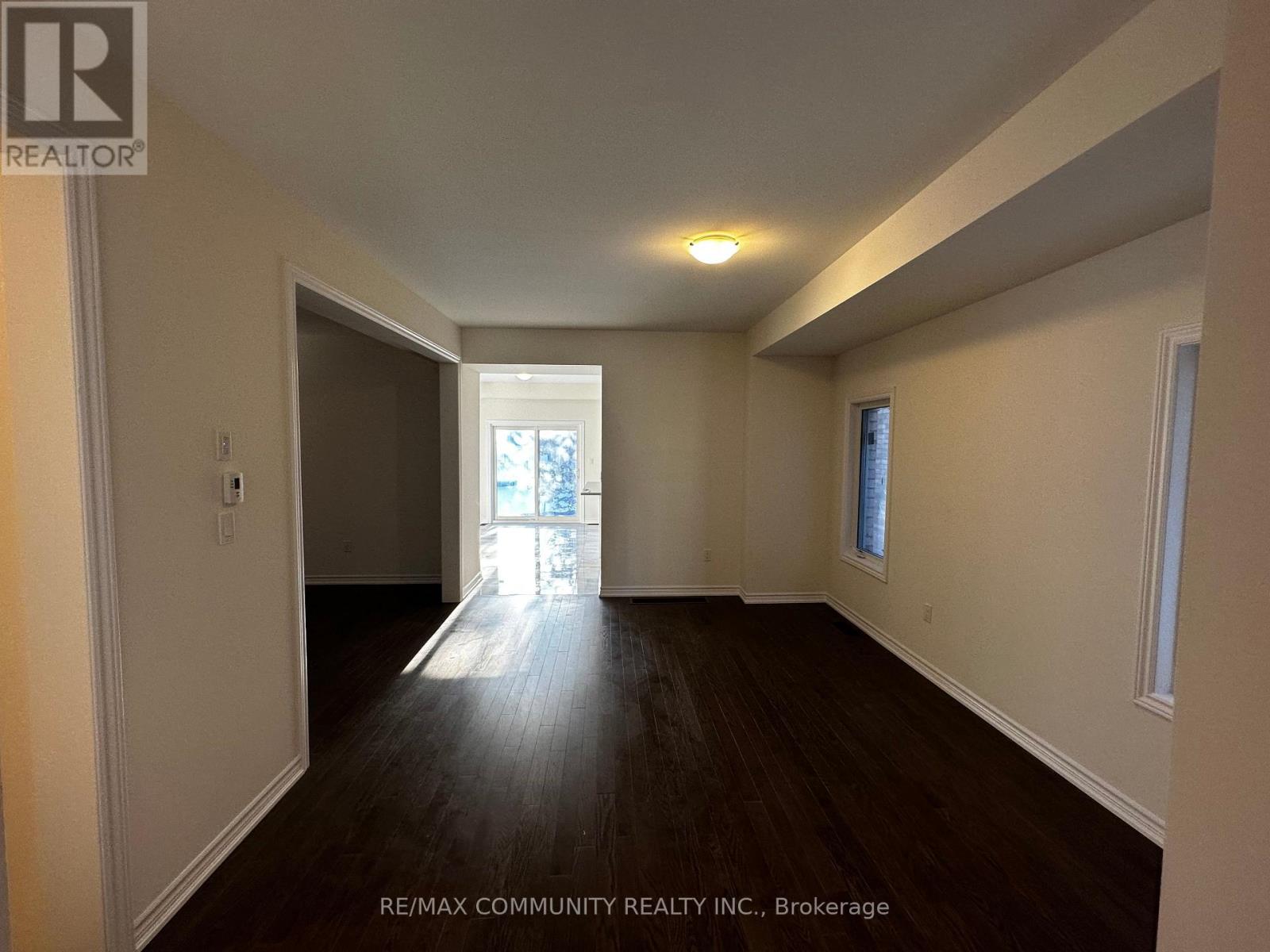A spacious room with wooden floors and white walls.
