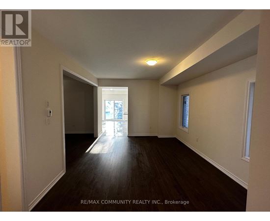 A spacious room with wooden floors and white walls.