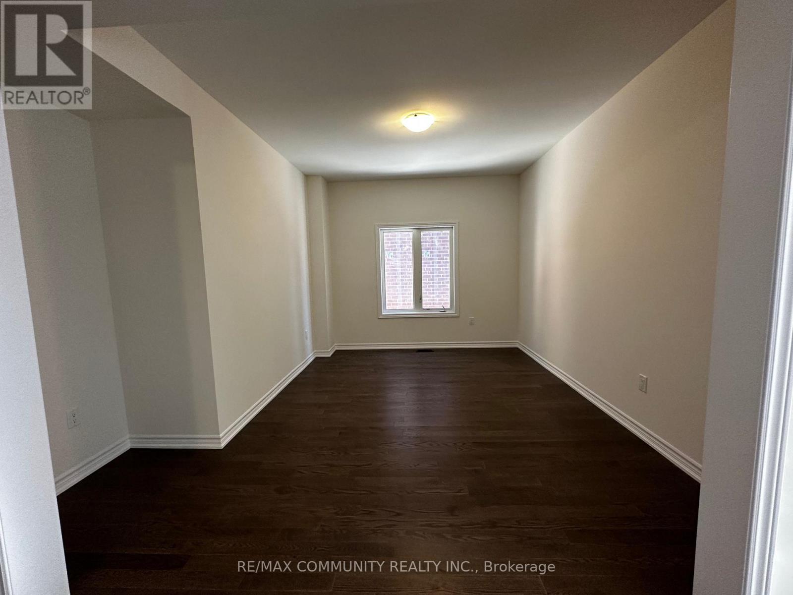 A room with a window and wooden flooring.