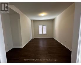 A room with a window and wooden flooring.