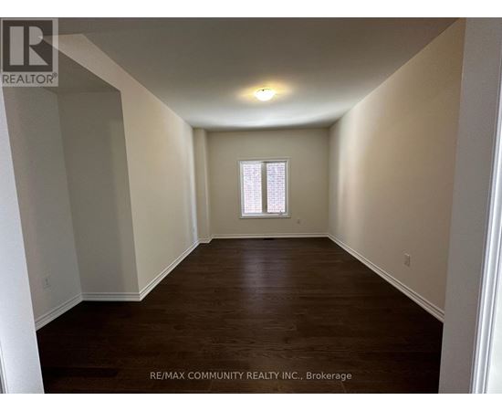 A room with a window and wooden flooring.