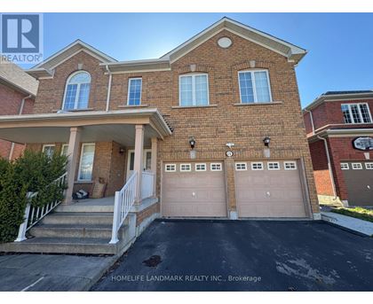 A brick house with a garage door is for sale.