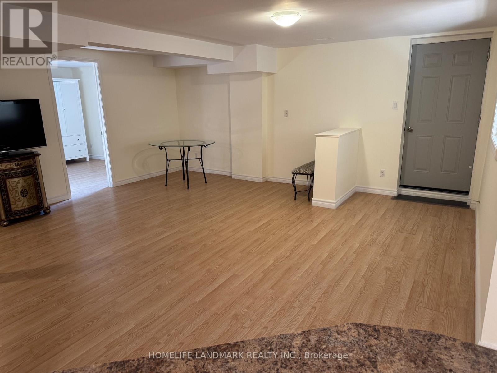 A living room with a wooden floor and a grey door.