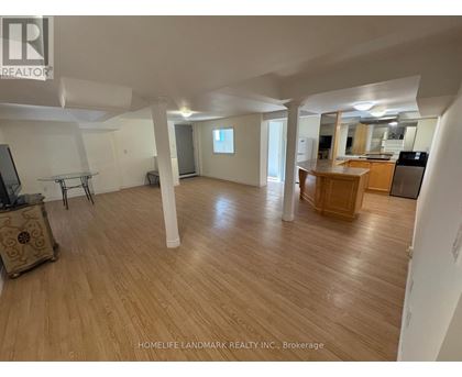 A spacious room with wooden flooring and white walls.