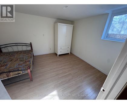 A bedroom with a bed, dresser, and window.