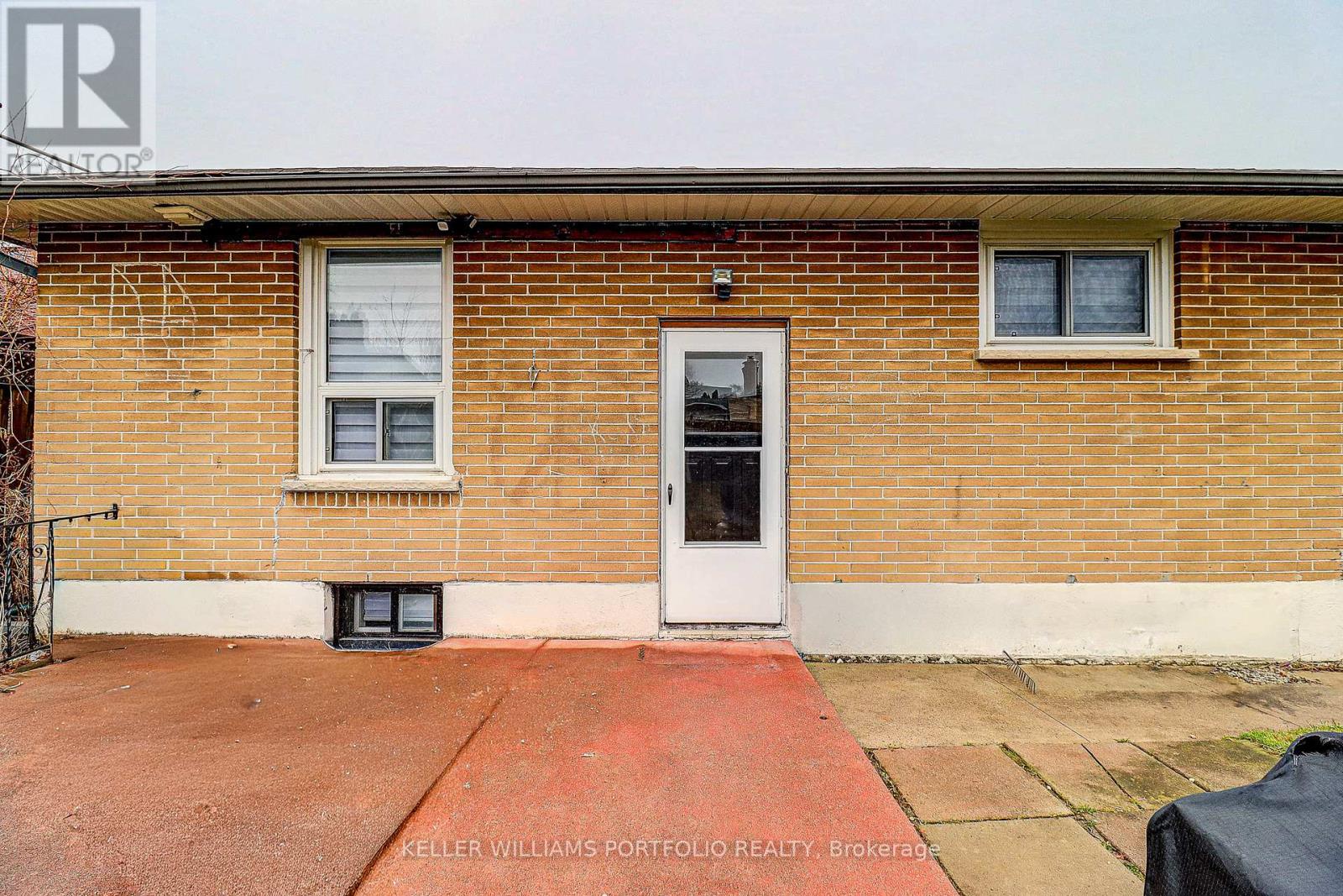 A brick house with a black door and windows.