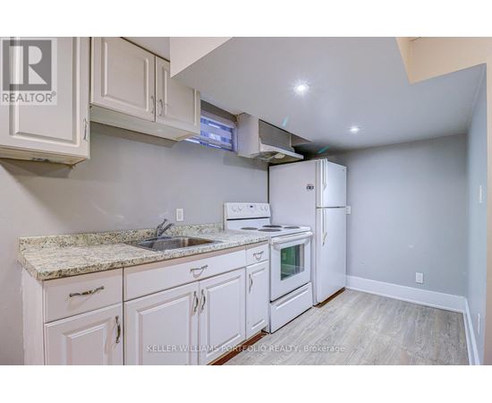 A kitchen with white cabinets and a granite countertop.