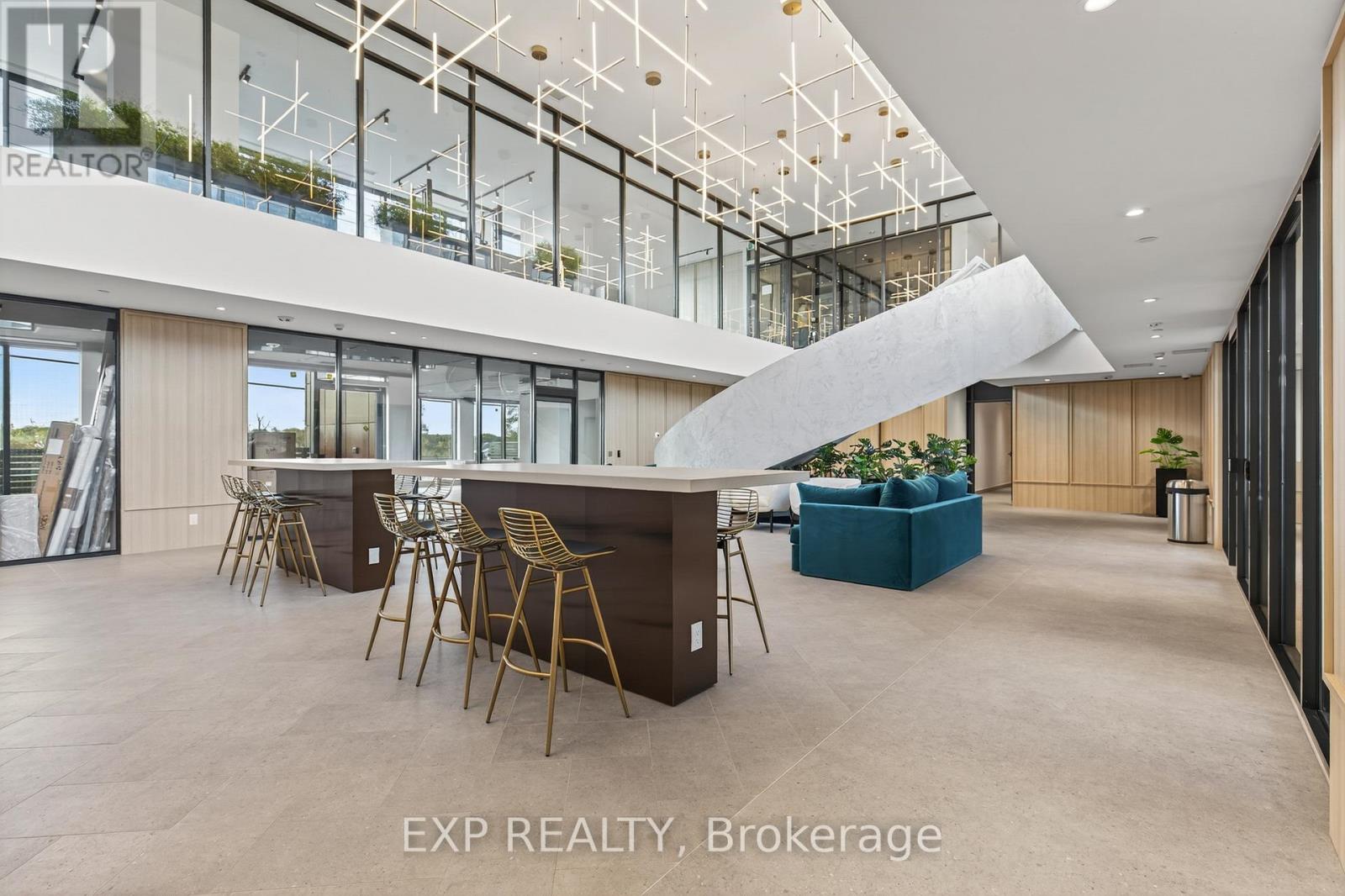 A spacious room with a long table and chairs, a sofa, and a glass wall with a view of the outside.