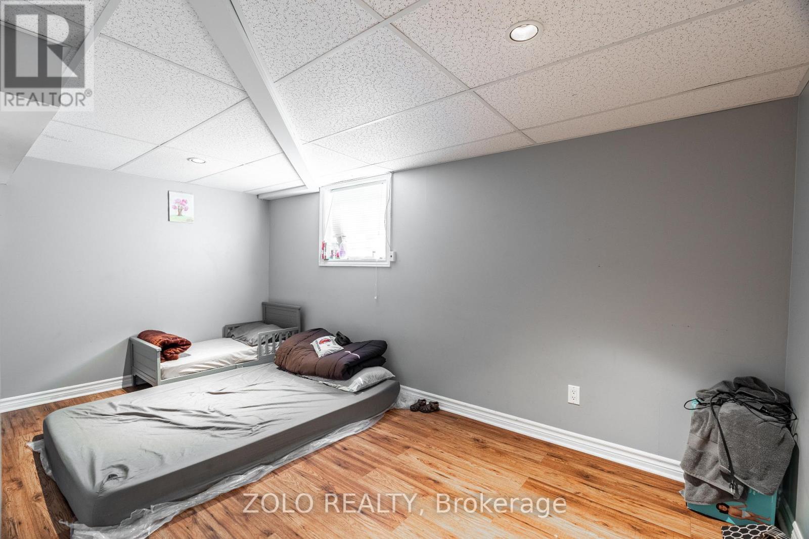 A bedroom with a bed covered in a grey blanket.