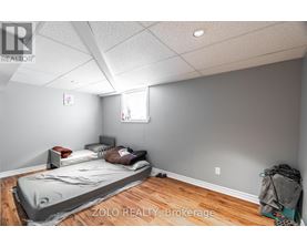 A bedroom with a bed covered in a grey blanket.