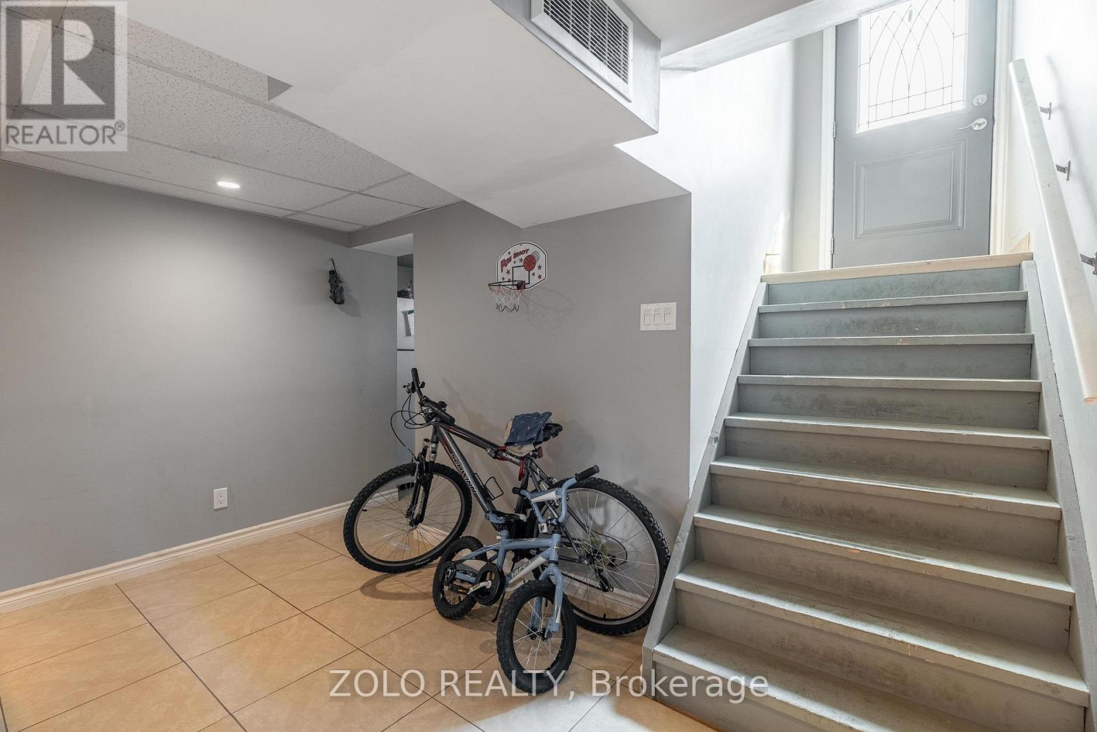 A room with a staircase and a bicycle.