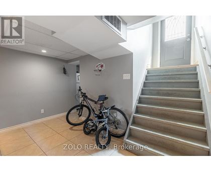 A room with a staircase and a bicycle.