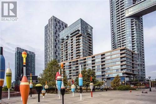 A cityscape with tall buildings and colorful sculptures in the foreground.