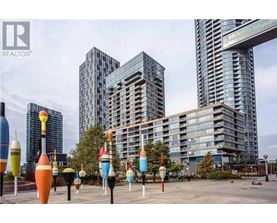 A cityscape with tall buildings and colorful sculptures in the foreground.