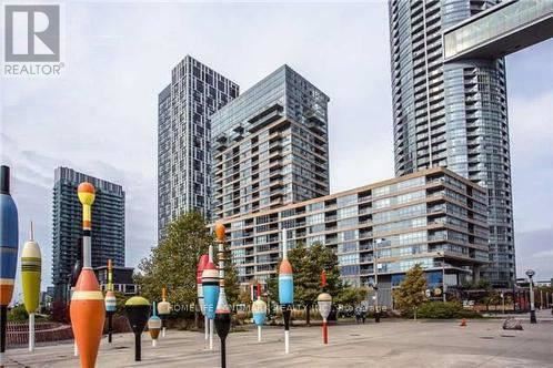 A cityscape with tall buildings and colorful sculptures in the foreground.