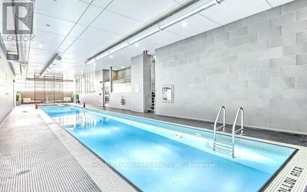 A large indoor swimming pool with a diving board.