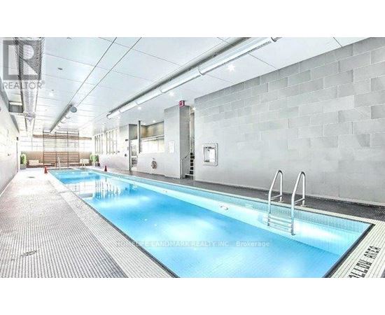 A large indoor swimming pool with a diving board.