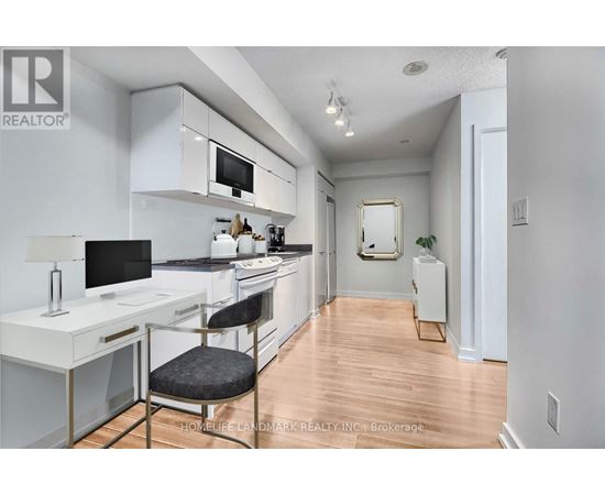 A kitchen with white cabinets and a black countertop.