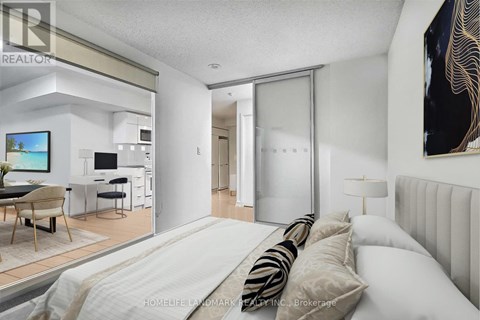 A bedroom with a large bed and a television in the living room.
