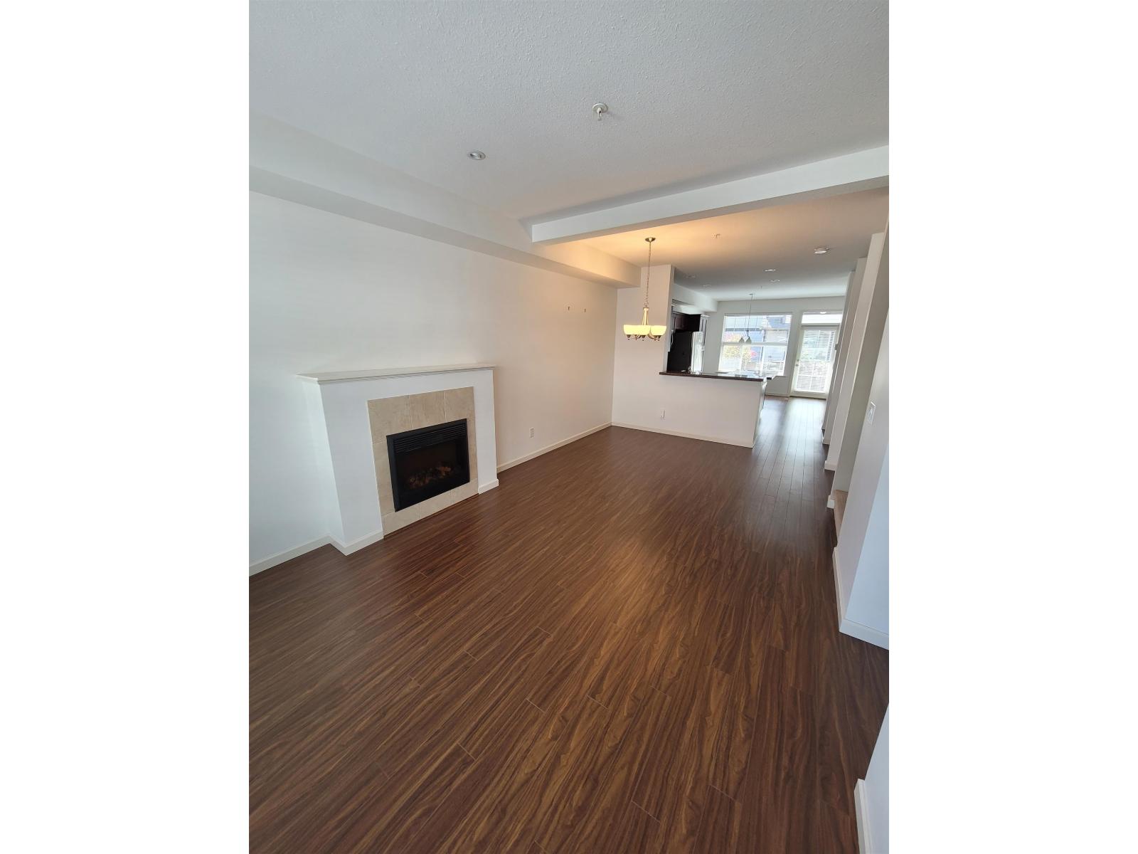 A room with a fireplace and wooden floors.