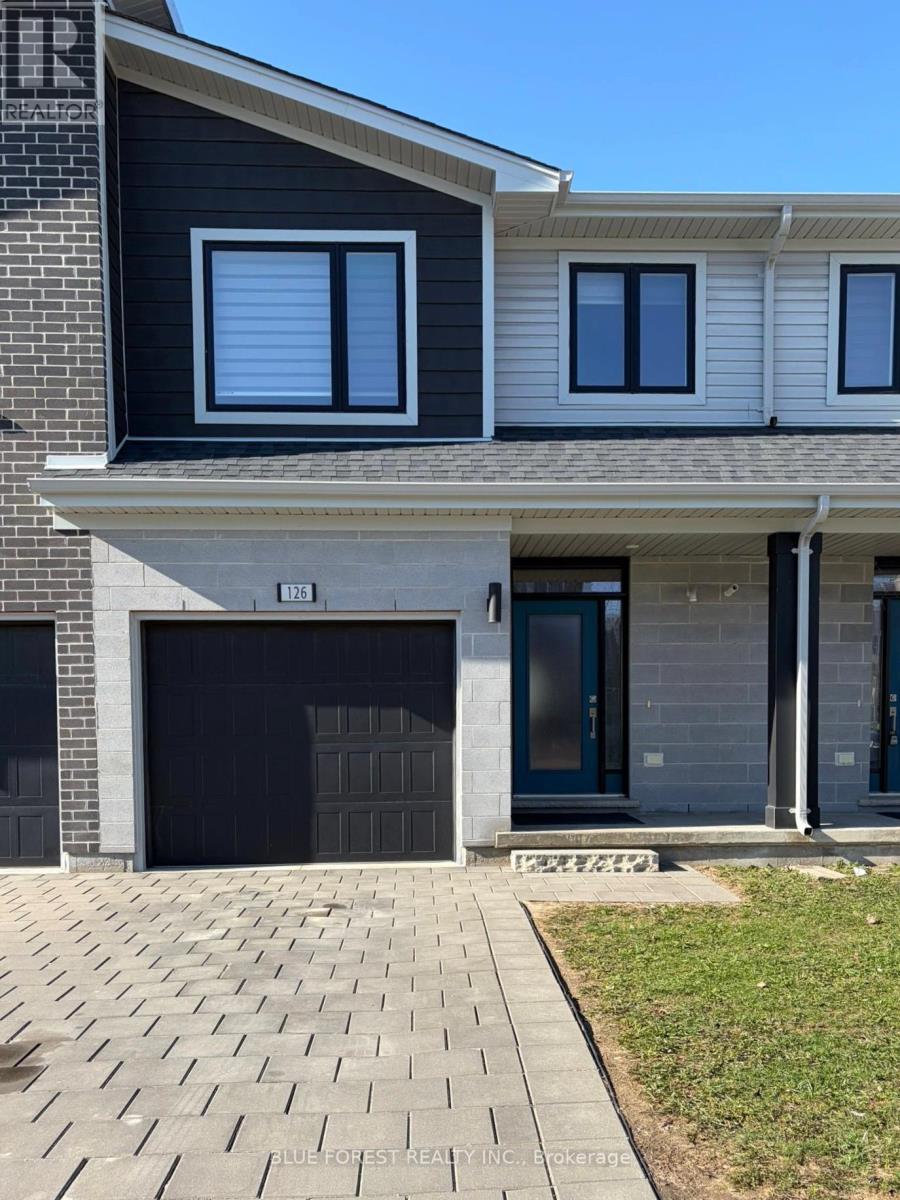 A modern house with a black garage door is for sale.