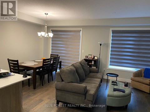 A living room with a grey couch and a dining table.