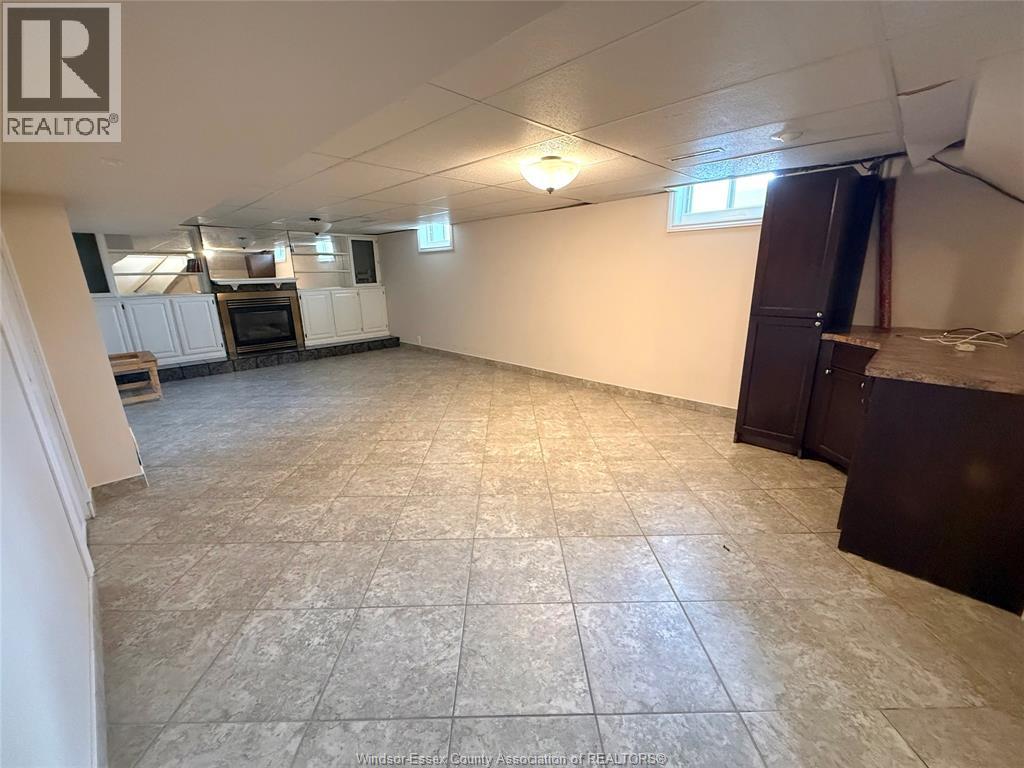 A spacious empty room with tile flooring and a window.