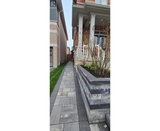 A concrete walkway leads to a house with a white porch.