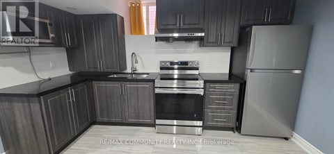 A kitchen with dark wood cabinets and stainless steel appliances.