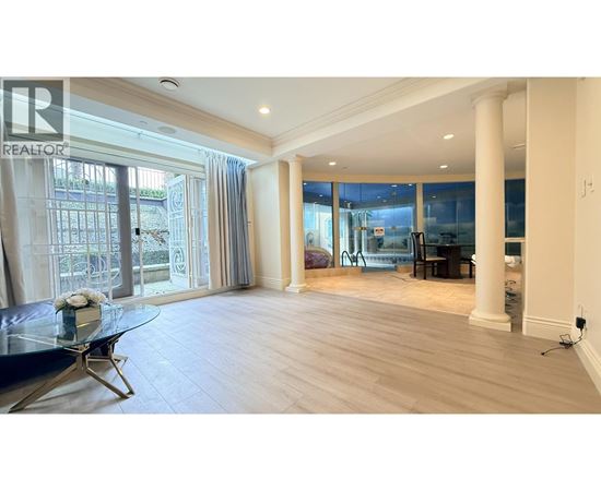A spacious living room with a glass table and a view of the outside.