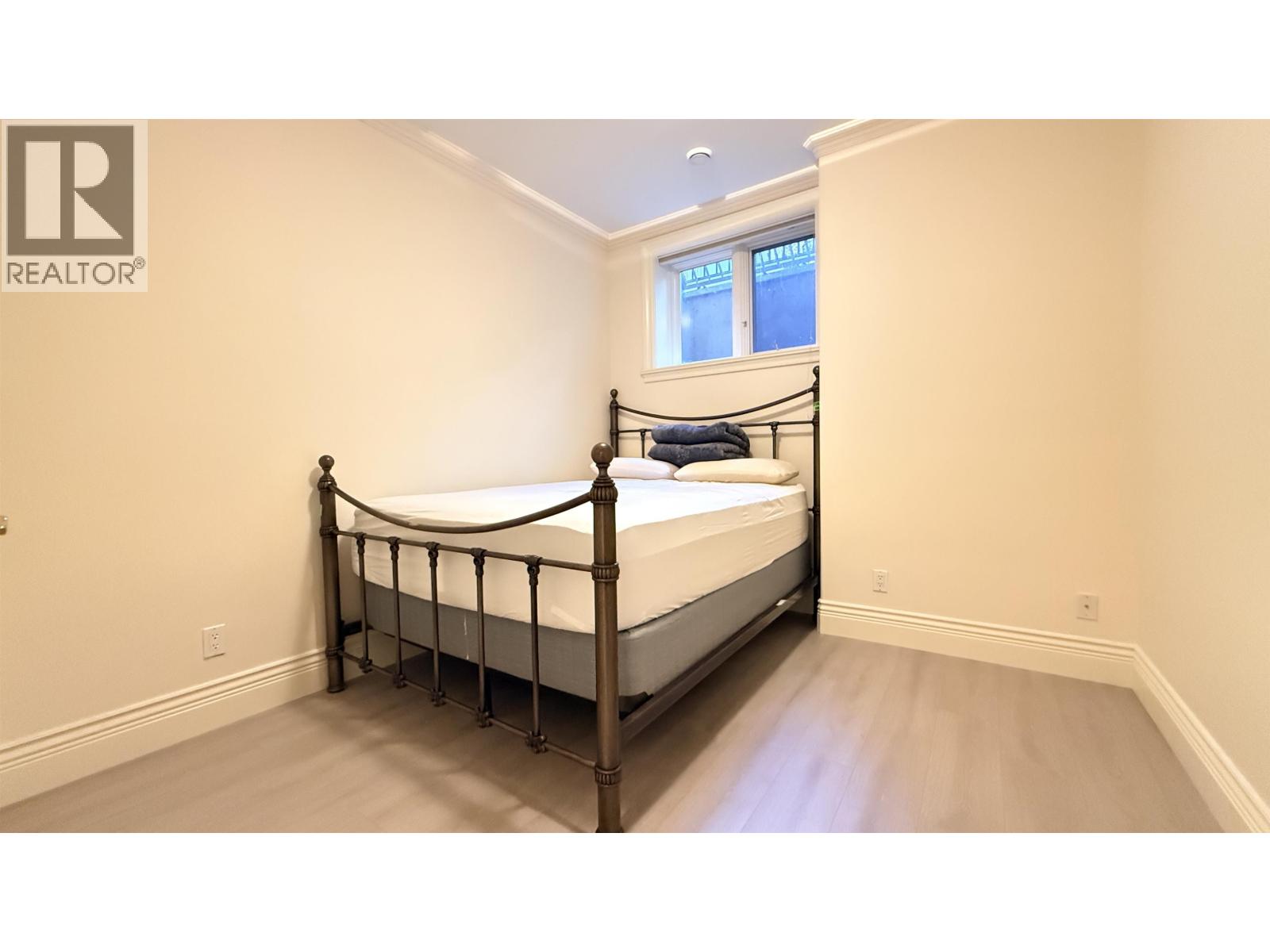 A bedroom with a four-poster bed and a window.