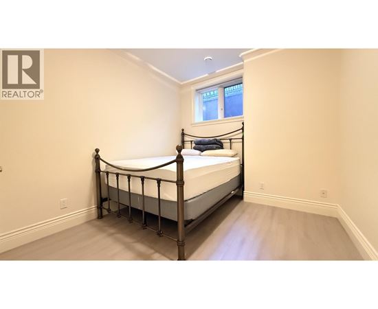 A bedroom with a four-poster bed and a window.