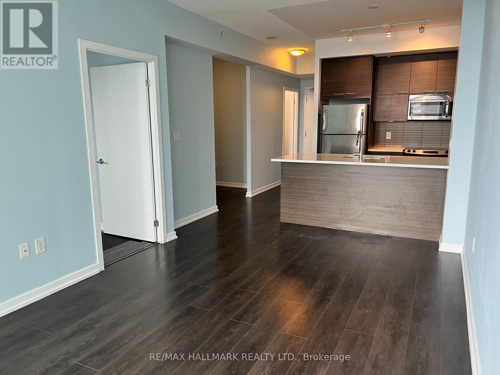A spacious kitchen with a refrigerator, microwave, and oven.