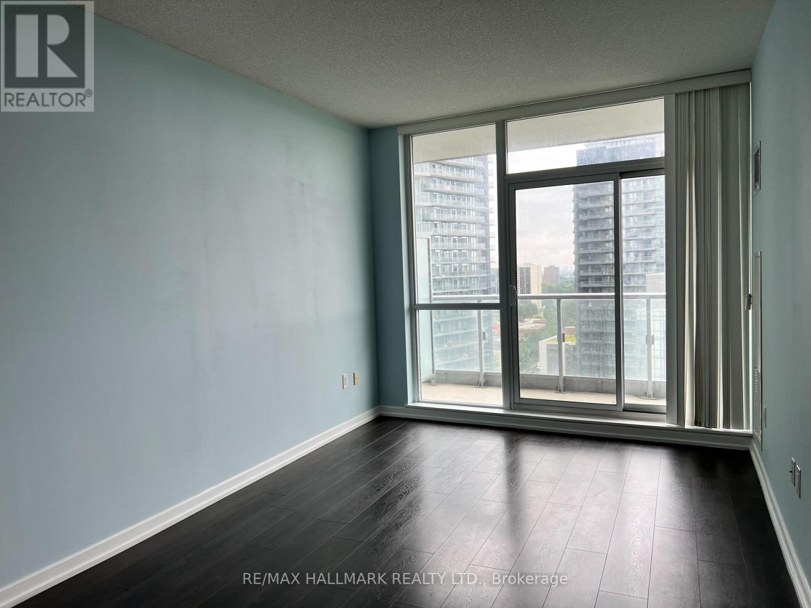 A room with a view of a cityscape through large windows.