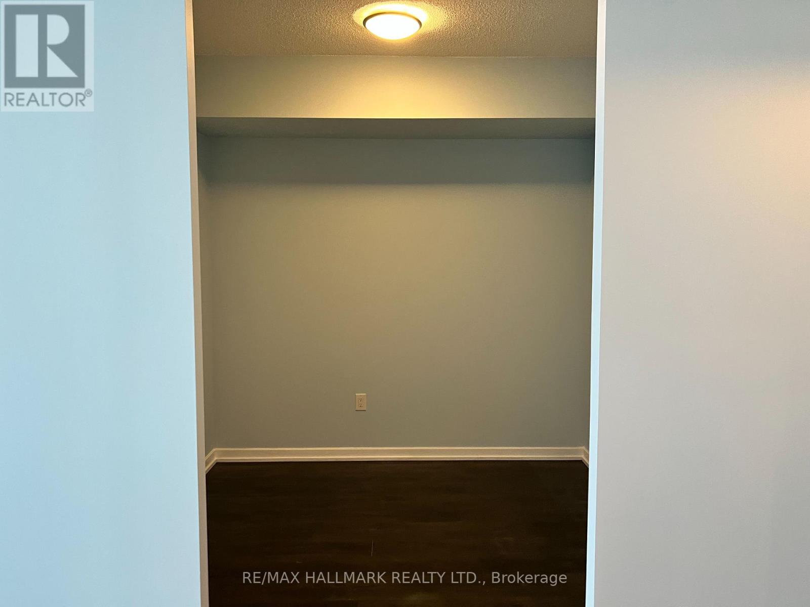A room with a light on the ceiling and a wall with a switch.